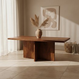  A large, rectangular wooden dining table with a bullnose edge and a Greek cross design base. The table is available in 180 cm, 200 cm, and 240 cm sizes. The table has a warm, natural wood finish that complements the minimalist, modern style.