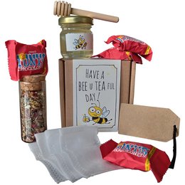 "A gift set containing a jar of honey, a bee-themed tea towel, and a card with a bee-themed design. The set is perfect for tea lovers and those who appreciate nature-inspired gifts."