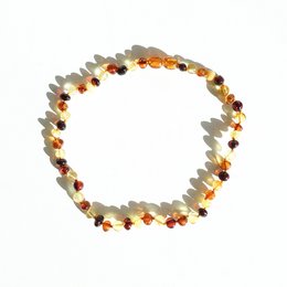 Amber toddler necklace with a mix of amber, red, and yellow beads in a circular design.