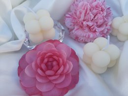 Tall, round, white scented candle with a pink floral accent.