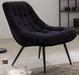 Oversized black velvet armchair with metal legs, modern and comfortable design.