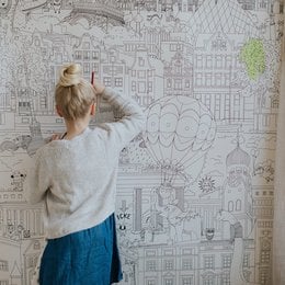 This wallpaper features a whimsical, hand-drawn cityscape design with colorful illustrations of buildings, trees, and other elements. The design is suitable for a child's room, with a playful and imaginative style.