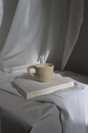 Glossy handmade ceramic cups in a minimalist, modern design. Features a simple, curved shape with a neutral color palette.