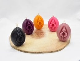 A round, tall pillar candle made of beeswax, available in black, purple, yellow, pink, and rose ash colors.