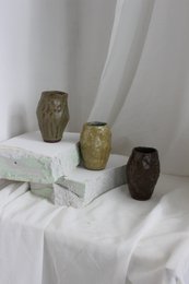 A handmade, matte gray vase with a simple, cylindrical shape.