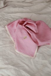 Soft, cozy linen baby swaddle in a variety of neutral colors including forest green, caramel, sea blue, white, gray, beige, powder pink, and candy pink. Features delicate lace trim for a touch of elegance.