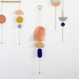 Decorative wall hanging with copper, nude, and cobalt blue porcelain circles in various shapes and sizes, creating a modern, minimalist design.
