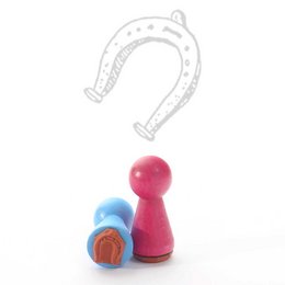 A small rubber stamp in the shape of a horseshoe. The stamp is made of colorful materials and appears to be part of a larger set or collection.