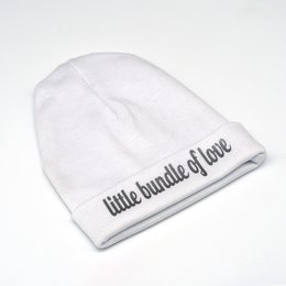 Soft, cozy white baby hat with "little bundle of love" text in gray. Perfect for keeping newborns and infants warm and stylish.