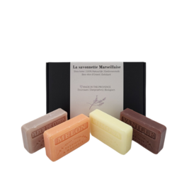 Assorted handmade soap bars in various scents including melon, cotton flower, vanilla, and mimosa. Rectangular shaped bars in pastel colors.