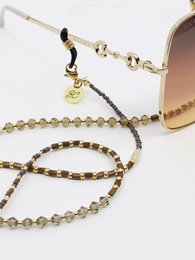 Gold-toned beaded eyeglasses cord with a pendant charm.