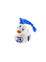  A small, ceramic duck ornament with a blue graduation cap and a blue and white floral design.