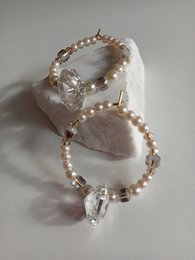 Elegant hoop earrings in white and black with pearl and crystal accents. Delicate and stylish accessory.