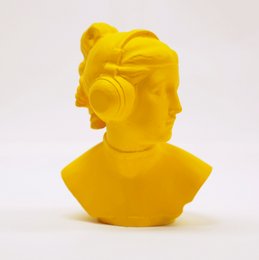 Vibrant yellow statue of a futuristic female figure with headphones, capturing a modern, technological aesthetic.