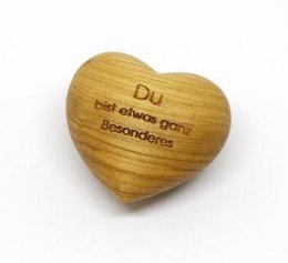 Wooden heart-shaped statue with the text "Du bist etwas ganz besonderes" (You are very special) engraved on it. The statue is made of natural wood and has a simple, rustic design.