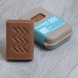 Rectangular brown soap bar with a textured surface and a teal and white label featuring a zigzag pattern. The product is described as "Morocco Mountain Almond & Rassoul Soap" and is categorized as a "Soap Bar".