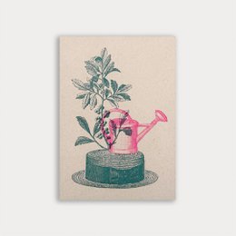  Postcard with a pink and teal watering can illustration, featuring a plant with green leaves and pink berries. The watering can is placed on a green base.