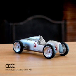 Silver vintage racing car with number 5 on the side, featuring a streamlined body and large wheels.