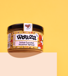 Salted caramel hazelnut spread in a glass jar with a brown lid. The product is labeled "Wowza" and contains a heart-shaped logo.