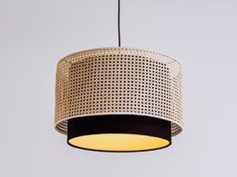 A round, pendant lamp with a woven rattan shade and a warm, yellow light source. The lamp has a simple, minimalist design that would complement a variety of interior styles.