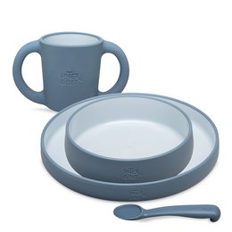 A blue and gray kids meal set with a plate, bowl, and spoon. The set features a round, shallow bowl and a cup-like bowl with two handles.