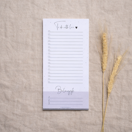A simple, minimalist to-do notepad with a lined design and a heart icon. The notepad is accompanied by a dried wheat stalk, creating a natural, rustic aesthetic.