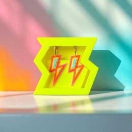  Neon yellow stud earrings with red lightning bolt design, geometric shape, bold statement style.