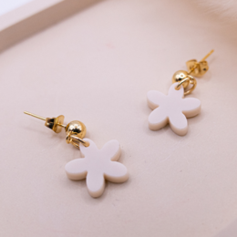 Beige acrylic flower stud earrings with gold-tone metal accents.