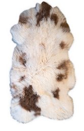 A large, fluffy, multicolored sheepskin rug with a natural, earthy appearance. The rug features a mix of light and dark brown tones, creating a unique and textured design.