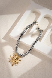  Elegant gold-toned sun pendant necklace with beaded chain in a chic, stylish design.