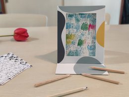 A reusable coloring pouch in a photo frame. Colorful abstract shapes and patterns on the frame. Suitable for kids' coloring activities.
