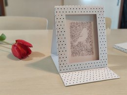 Reusable gift pouch in a photo frame with a polka dot pattern. The pouch can be used to hold small gifts or photos.