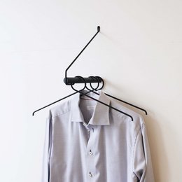 Black oak clothing rack with black metal frame and hangers.