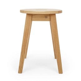 Solid oak stool with a round, natural wood seat and four sturdy, tapered legs for a timeless, stylish look.