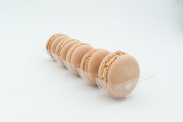 Delicate, round macarons in a light caramel color with a smooth, glossy surface.