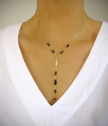 Gold Y-shaped necklace with black Swarovski crystals, a delicate and elegant lariat style necklace.