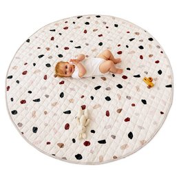 A round, quilted play mat with a confetti-like pattern in various colors. The mat is 1.5 meters in diameter and 1.5 cm thick, providing a soft and comfortable surface for babies and young children to play on.