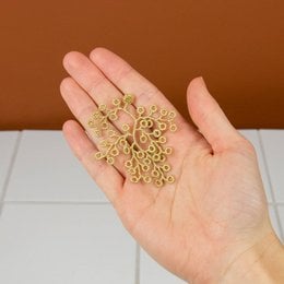 Intricate golden brooch with embroidered spikemoss design, suitable for formal or casual wear.