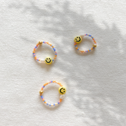 Colorful beaded charm bracelets with smiley face charms.