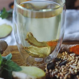Organic ginger turmeric tea with natural ingredients including ginger, turmeric, and other spices. Brewed tea has a warm, earthy flavor.