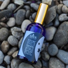Organic pillow mist with a calming, soothing scent. Features a blue glass bottle with a gold cap.