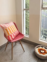 Soft, jacquard-knitted cotton pillow cover in a vibrant pink and orange striped pattern. Available starting April 1st.