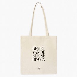  A white cotton tote bag with the text "de leukste JUF" (Dutch for "the nicest teacher") printed in black. The bag has a simple, minimalist design and appears to be a stylish accessory or gift for a teacher.