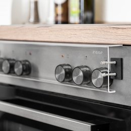 Stove knob cover, round metal knobs, black oven door, stainless steel appliance