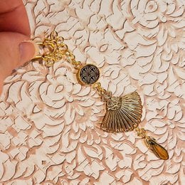 Bohemian-style hair pin with gilded brass beads, seashell, and turquoise accents. Ideal for adding a touch of chic to any hairstyle.