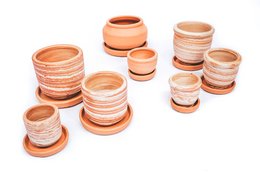 A collection of small, round terracotta plant pots in various sizes, featuring earthy tones and simple, minimalist designs.