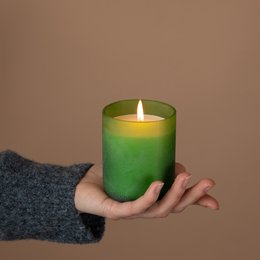 Organic scented candle in a green glass container with a floral, earthy aroma inspired by an English garden.