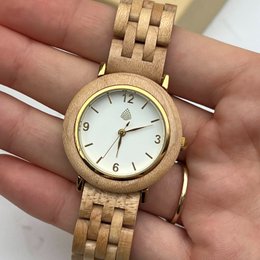 Handmade wood vegan watch with a natural, minimalist design. Features a wooden case and band, with a simple white dial and gold-tone accents.