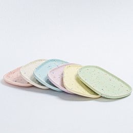 Decorative tray set in assorted pastel colors, featuring a round, shallow design with a speckled texture.