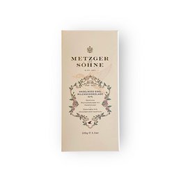 "Milk chocolate bar with roasted hazelnuts, beige packaging, premium design, Mützger Söhne brand"